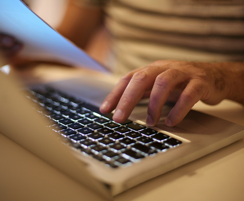Close-up of hands typing on a laptop
