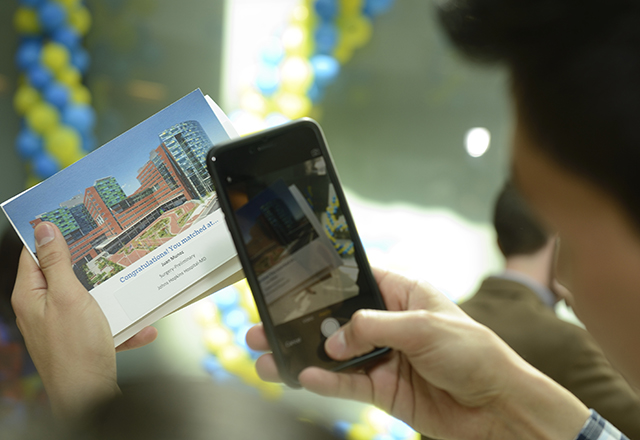 student taking picture of match day card