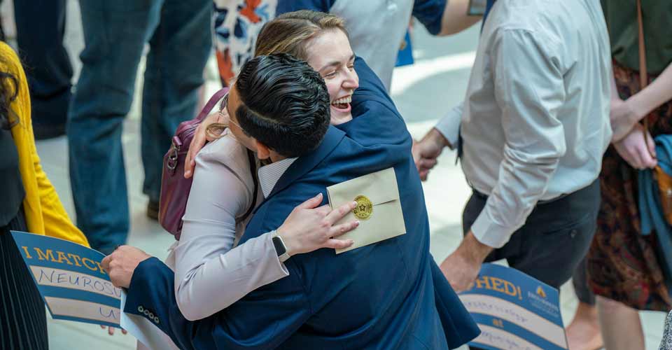 A congratulatory hug is shared.