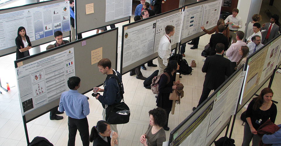 Symposium attendees view research posters.