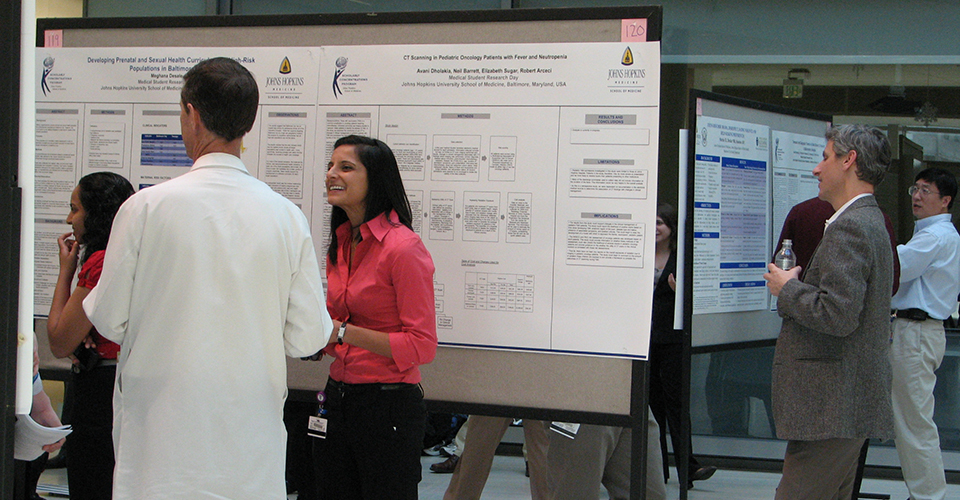 Symposium attendees discuss research posters.