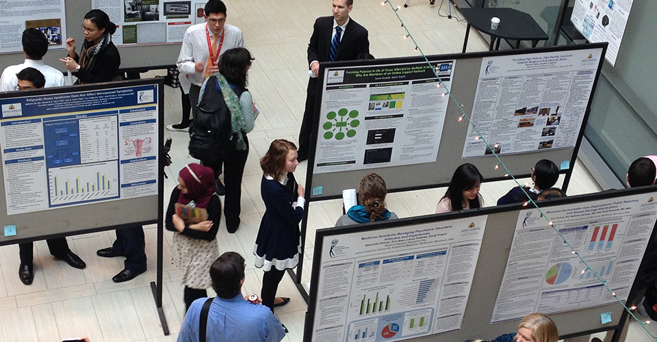 Symposium attendees browse research posters.