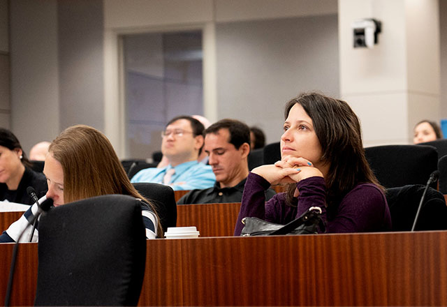 Faculty members listening to a seminar.