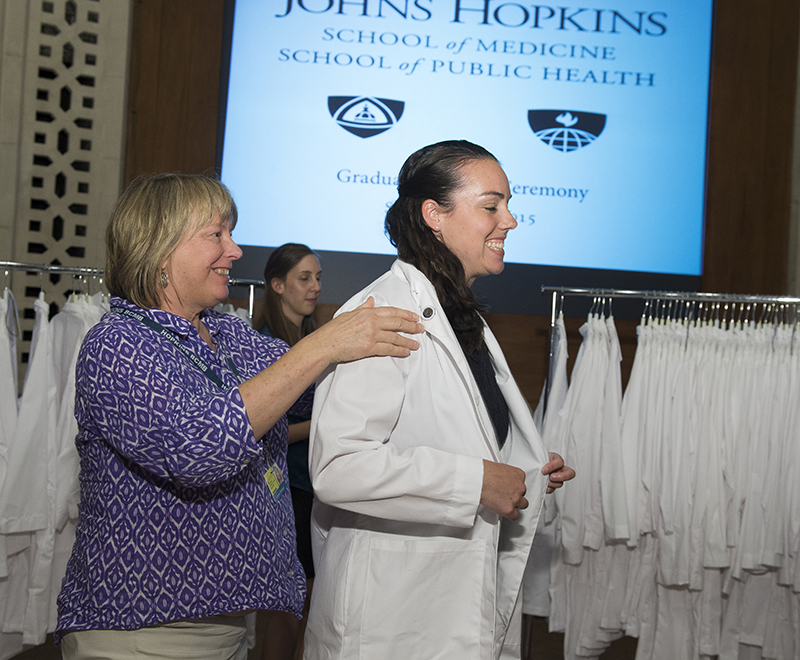 A graduate student receives her white coat.