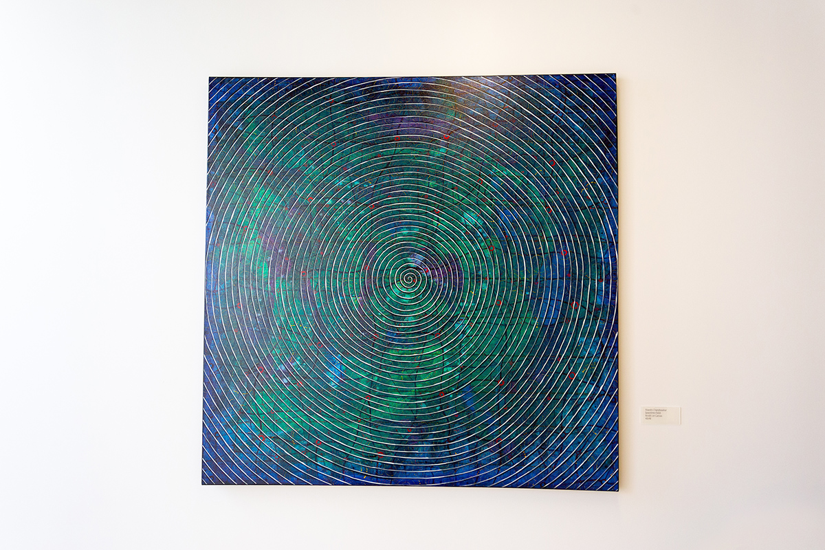 Photograph of Shanthi Chandrasekar's Spacetime-Flow, a golden spiral on a blue-green background.
