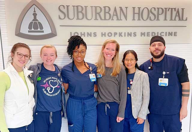 Nurses standing in front of the Suburban Hospital logo.