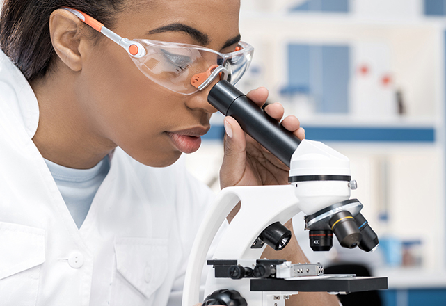 hpb surgery research - woman using microscope and wearing goggles