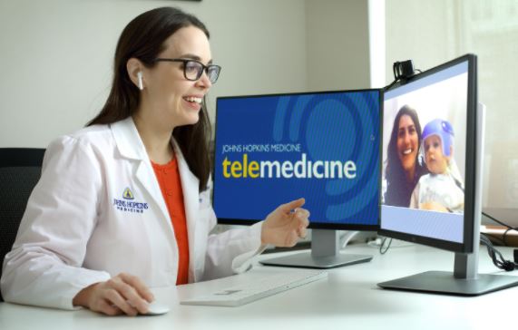 A provider conducts a telemedicine appointment with a woman and her child
