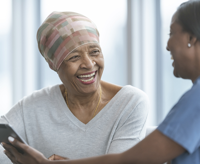 mature woman with cancer laughing with nurse