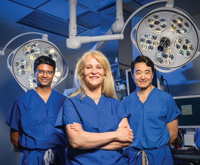 Dr. Ramulu, Dr. Akpek and Dr. Handa standing in an operating room