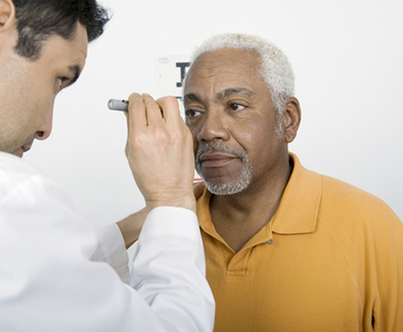 doctor examining mature man's eye