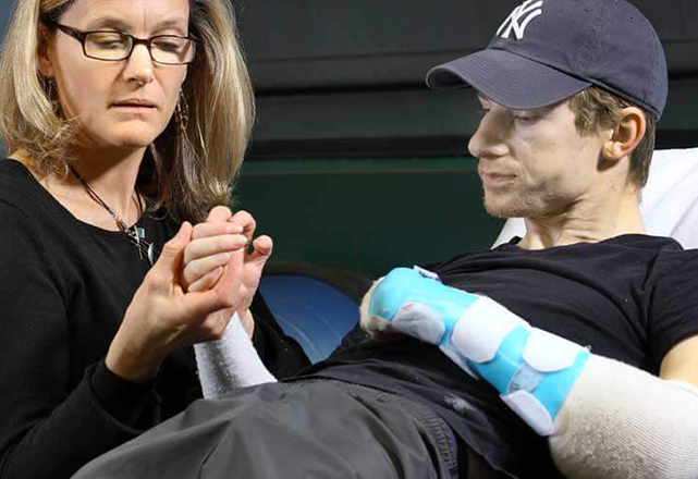woman examines arm of transplant recipient