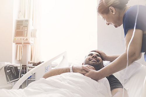 man smiling in hospital bed