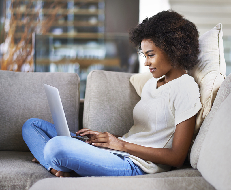 woman using laptop sitting on couch