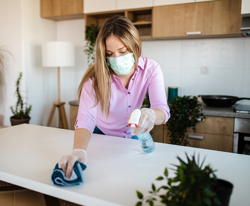 transplant - woman cleaning table wearing mask covid19