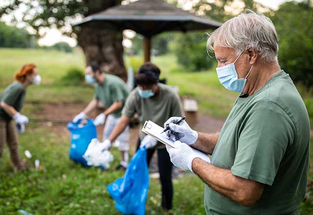 Masked volunteers cleaning up a park.