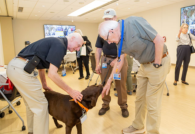 Older patients petting a service dog.