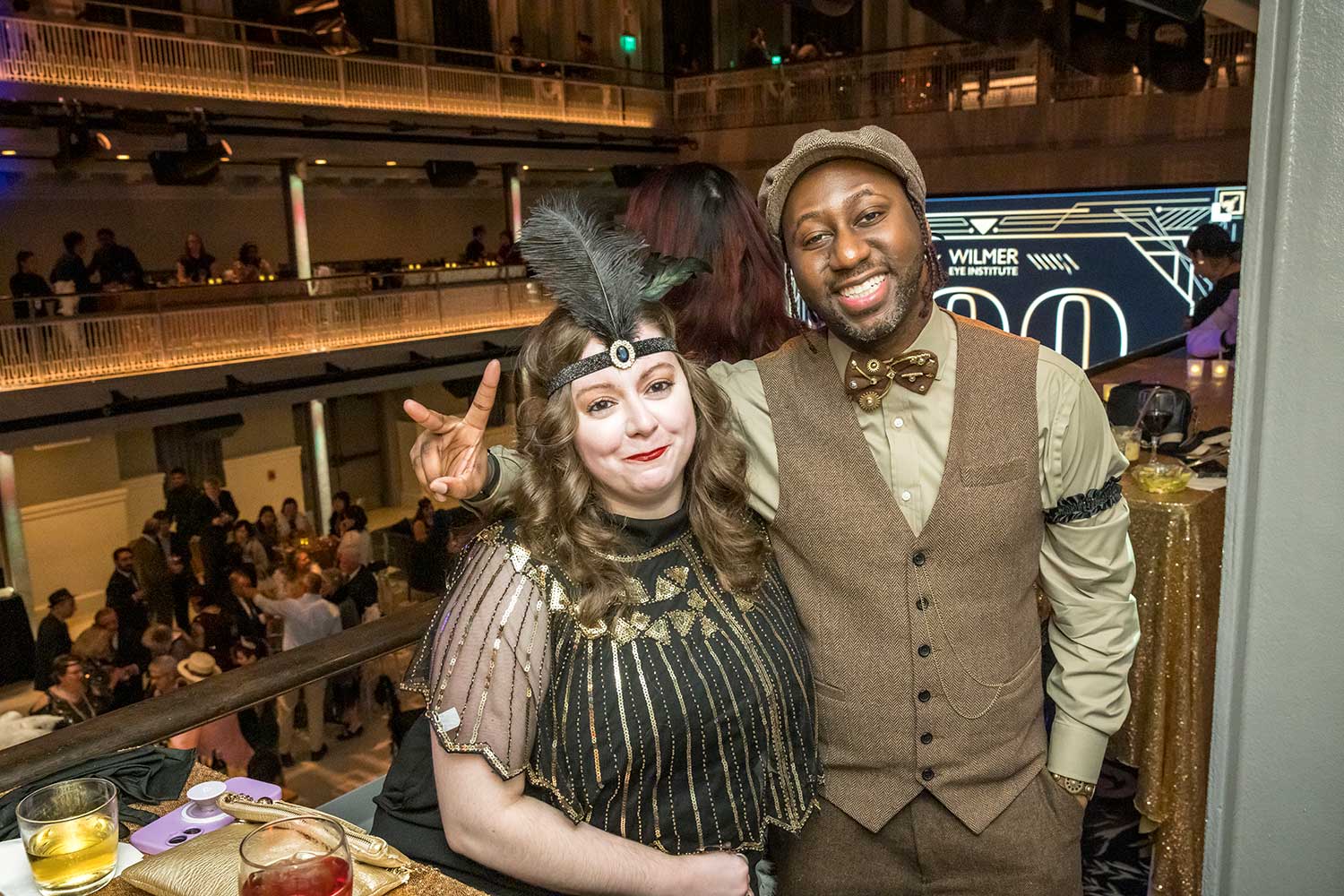 Two smiling attendees in 20s attire