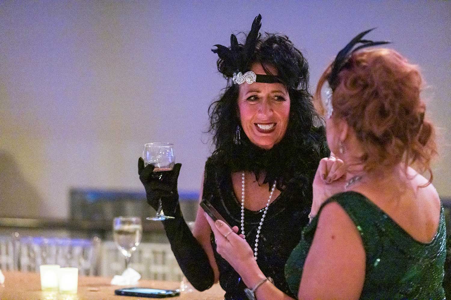 Two women speaking together, both dressed as flappers
