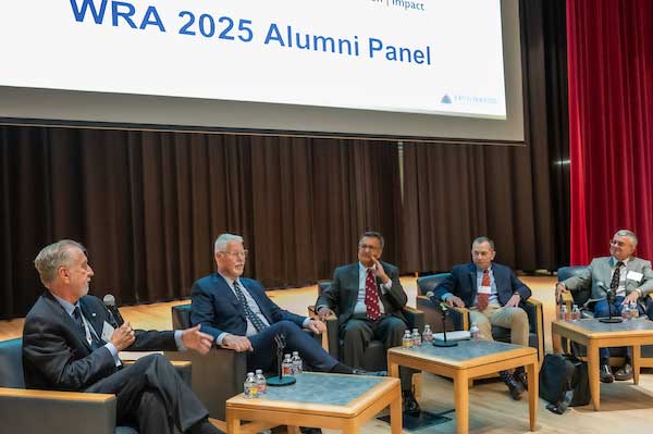 Panel participants seated on stage