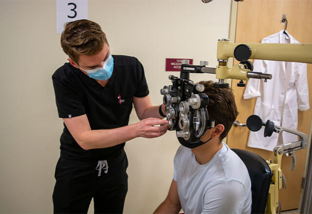 Bryce Patrick St. Clair conducts an eye exam for a patient at CASA.