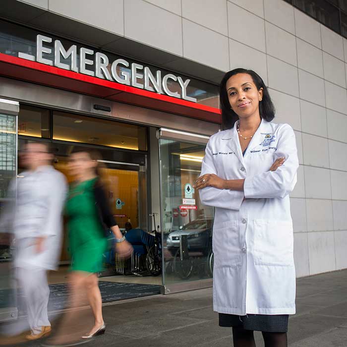 Doctor Woreta in a white coat standing in front of the emergency entrance
