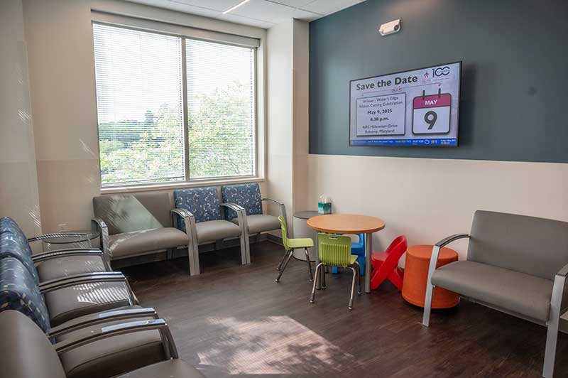 Corner of medical waiting room with bright window and mounted television screen