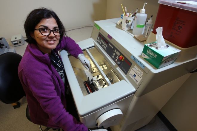 a woman uses microm cryostat machine