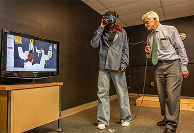 Professor of Ophthalmology Gislin Dagnelie, Ph,D., a pioneer vision mobility researcher at the Johns Hopkins University School of Medicine, demonstrates the use of virtual reality scenes in a head-mounted display to assess the vision of patients with advanced genetic eye disease. With a new, dedicated mobility lab, Wilmer is well-positioned to expand services in the northeast region, attract new clinical trials and work with collaborative partners to provide new treatments for blinding eye diseases. 