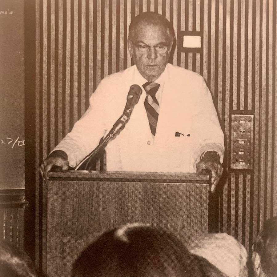 Edward Maumenee speaking at a podium
