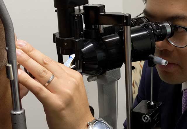 Doctor examines a patients eyes using a slit lamp