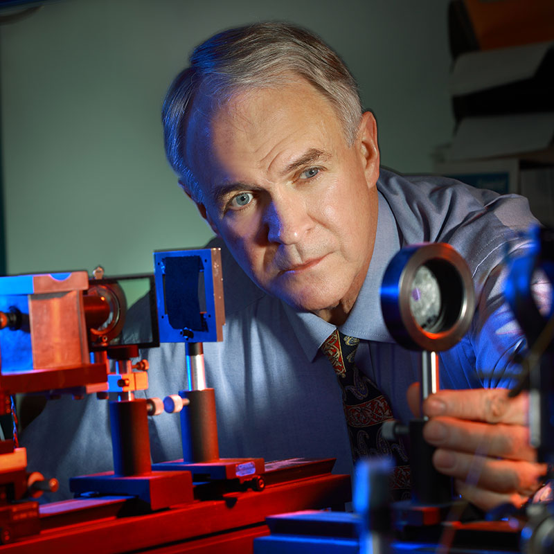 David Guyton examining a lens in an optic lab