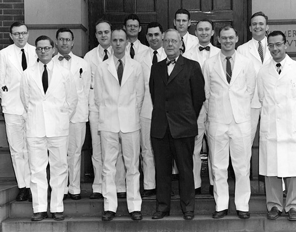 Black and white photo of a residency class standing on the steps of the Wilmer Eye Institute