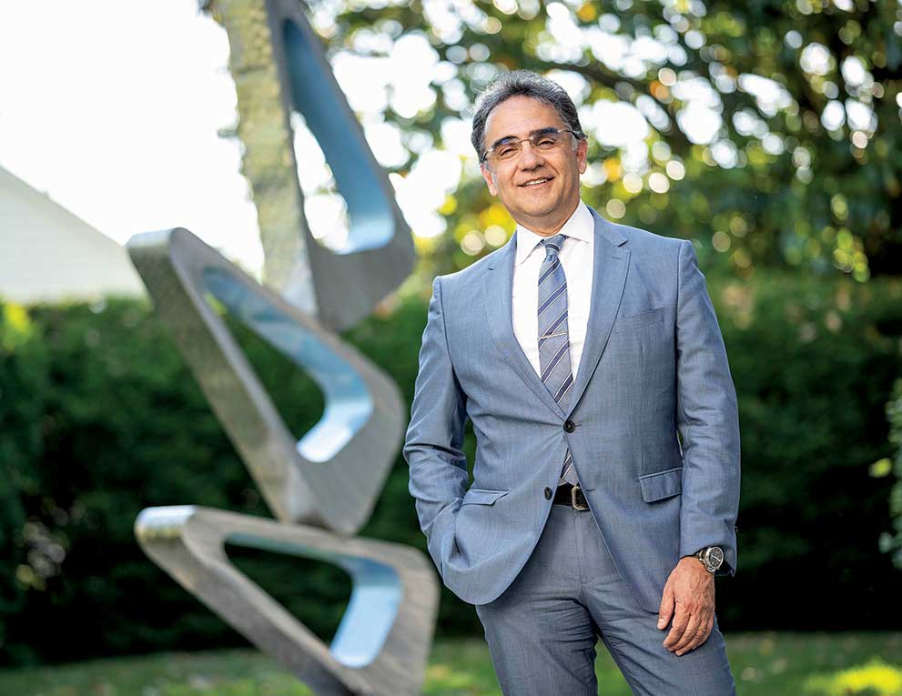 Ashley Behrens standing in front of an abstract sculpture in a garden