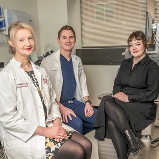 Meghan Berkenstock and Bryce St Clair in white coats sitting beside Kylie Myles