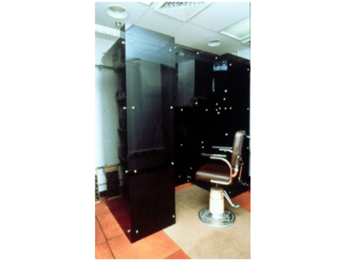 A dark glass enclosure with a chair in the middle