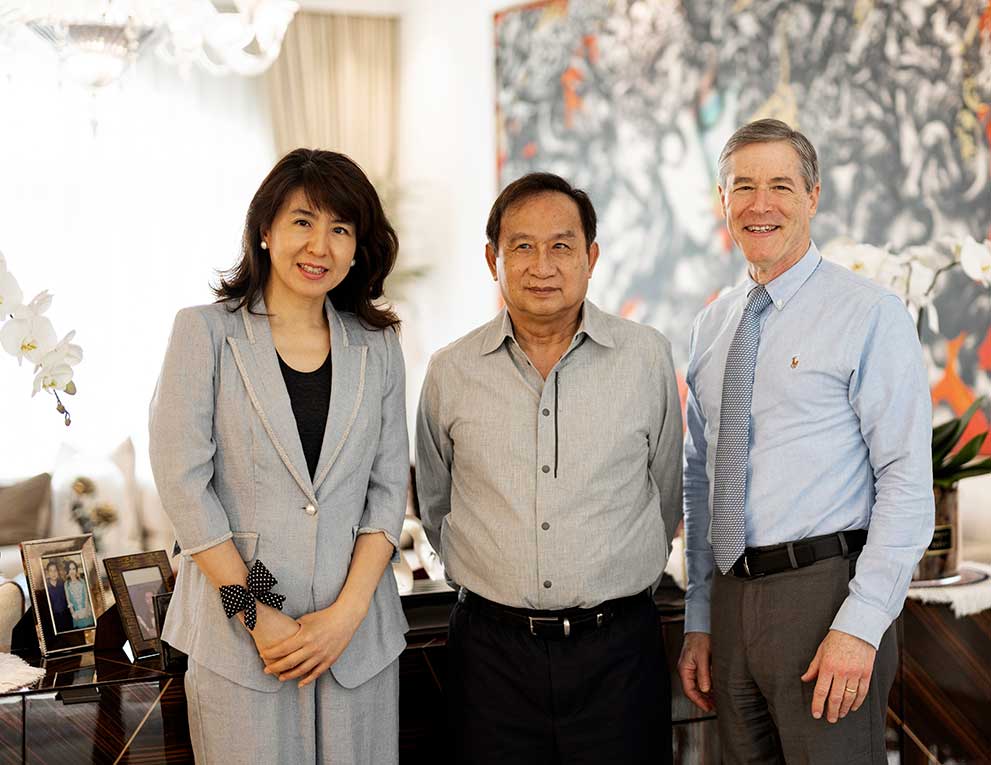 Jun Kong, Chalerm Yoovidhya and Neil Bressler smiling together in a bright living room