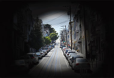 A rendering of what it's like to experience Retinitis Pigmentosa, showing a street viewed through a pinhole.