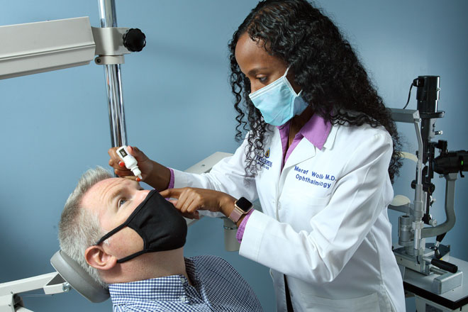 Dr. Meraf Wolle treats the eye of a patient