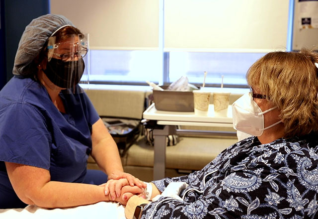nurse holds patients hand