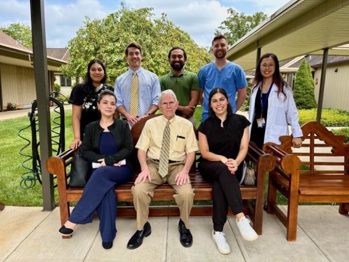female and male doctors sitting outside on a bench