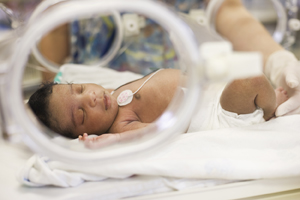Newborn baby in incubator.