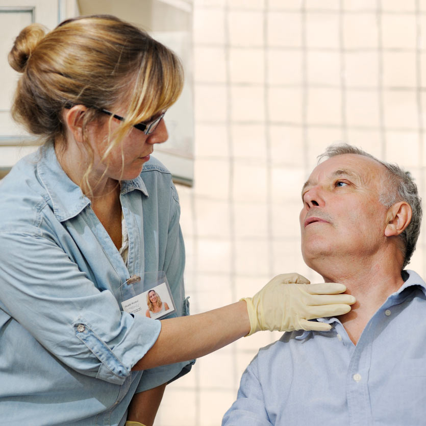 Doctor examining a male patient's throat
