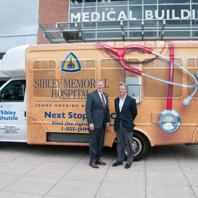 Sibley Memorial Hospital shuttle bus with two men standing next to it.