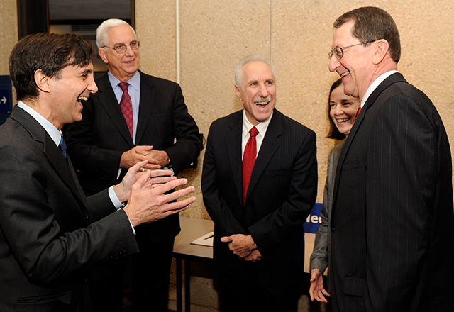 Rothman stands with his wife and a group of men, laughing and smiling.