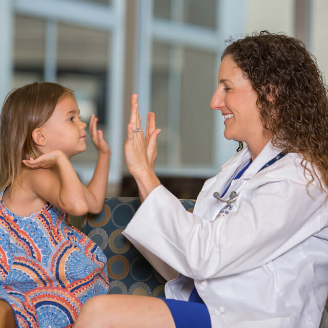 A photo shows a pediatric resident with a young patient.