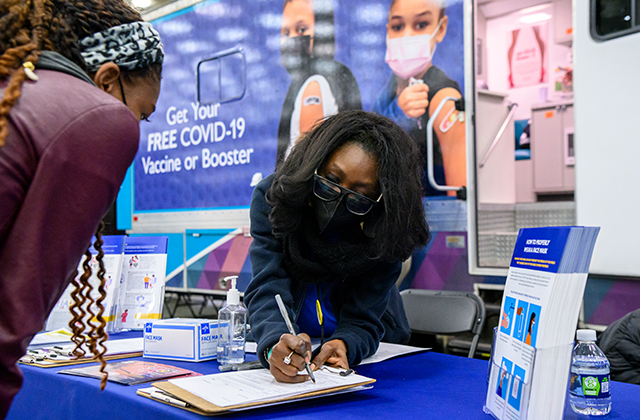 A CIAA Fan Fest attendee signs in to receive a COVID-19 vaccine.