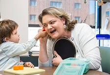Un niño con implantes cocleares se comunica con su audióloga. 