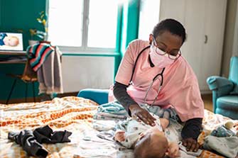 Home nurse caring for an infant patient