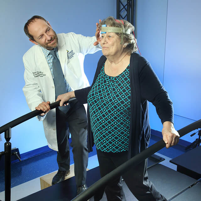 A photo shows Pablo Celnik applying transcranial direct current stimulation to a research participant. 
